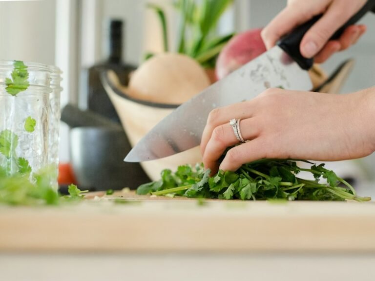 Hands chopping fresh herbs and vegetables for a healthy meal