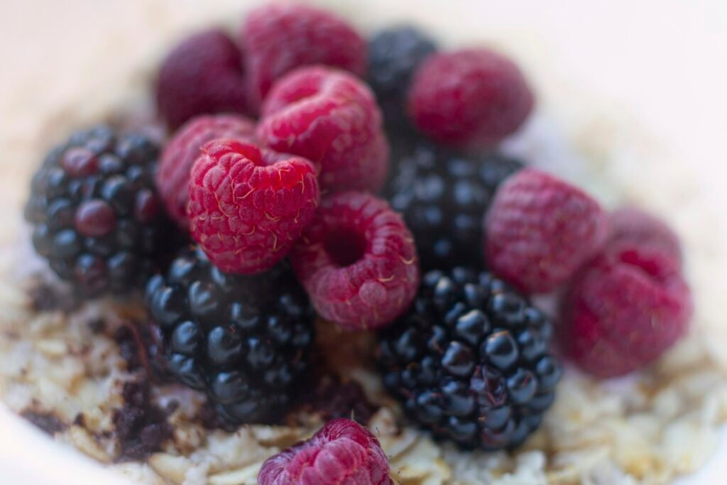 Bowl of oatmeal topped with raspberries and blueberries