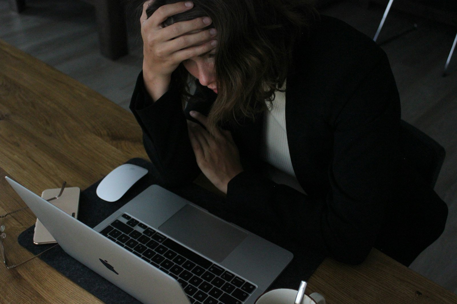 Tired woman resting her head in her hands at a laptop