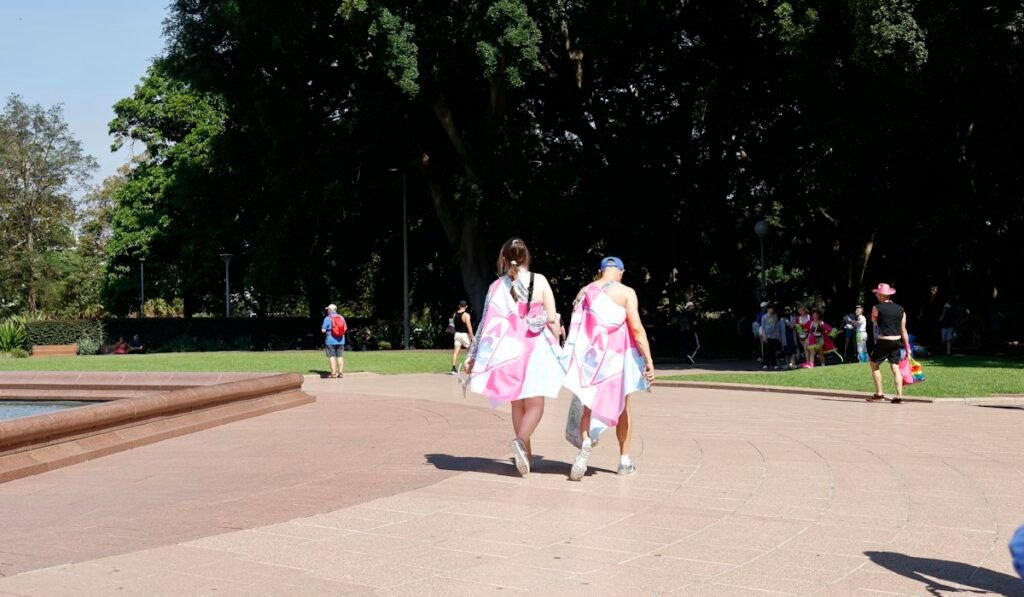 Two women walking in a park on a sunny day